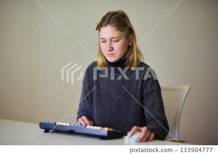 Determined individual with cerebral palsy immersed in educational activities indoors, Courageous woman with cerebral palsy concentrates on studying at home with dedication 133984777