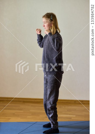 Woman exercises indoors, Individual with cerebral palsy performing warmup, Serene young woman with mobility challenges practicing controlled physiotherapy routines indoors 133984782