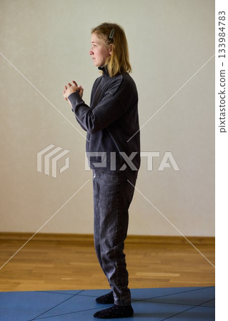 Woman exercises indoors, Individual with cerebral palsy performing warmup, Serene young woman with mobility challenges practicing controlled physiotherapy routines indoors Woman exercises indoors, Individual with cerebral palsy performing warmup, Serene young woman with mobility challenges practicing controlled physiotherapy routines indoors 133984783