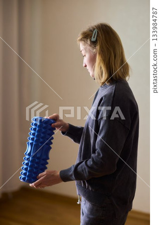Woman exercises indoors, Individual with cerebral palsy performing warmup, Serene young woman with mobility challenges practicing controlled physiotherapy routines indoors 133984787