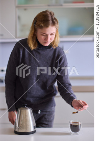 Cerebral palsy Serene female calmly pouring hot coffee into mug at home, Tranquil woman in cozy kitchen environment leisurely serving herself hot beverage during morning hours 133984818