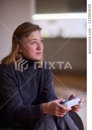 Casual female gamer with cerebral palsy, Relaxed woman with gaming controller, Young woman plays video game comfortably at home, Female gamer intently engaging with console in cozy living space Casual female gamer with cerebral palsy, Relaxed woman with gaming controller, Young woman plays video game comfortably at home, Female gamer intently engaging with console in cozy living space 133984828