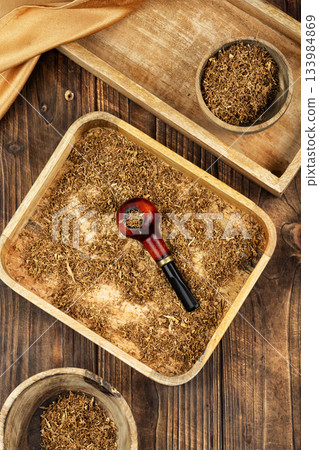 Tobacco pipe on rustic wooden table. Tobacco pipe on rustic wooden table. 133984869