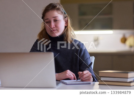 Determined individual with cerebral palsy immersed in educational activities indoors, Courageous woman with cerebral palsy concentrates on studying at home with dedication Determined individual with cerebral palsy immersed in educational activities indoors, Courageous woman with cerebral palsy concentrates on studying at home with dedication 133984879
