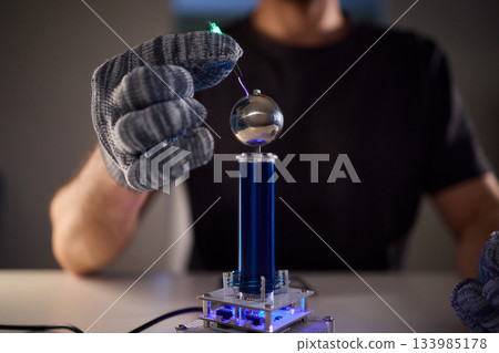 Expert carefully calibrates plasma equipment using sensitive techniques, Research professional employs meticulous methods to adjust plasma probe with expert precision 133985178