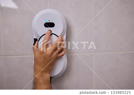 Smart robot performing quick hygienic maintenance in bathroom space, Modern robotic cleaner diligently scrubbing grout lines adjacent to toilet in bright tiled room Smart robot performing quick hygienic maintenance in bathroom space, Modern robotic cleaner diligently scrubbing grout lines adjacent to toilet in bright tiled room 133985225