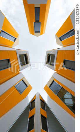 Bottom up view of bright modern yellow apartment buildings 133985379