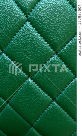 Green artificial leather surface texture, stitched in the form of rhombuses, squares, rectangles. Quilted eco-leather. Green artificial leather surface texture, stitched in the form of rhombuses, squares, rectangles. Quilted eco-leather. 133985604