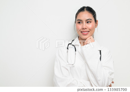 Happy Woman Doctor with Stethoscope in White Uniform on Plain Background Smiling and Thinking Happy Woman Doctor with Stethoscope in White Uniform on Plain Background Smiling and Thinking 133985700