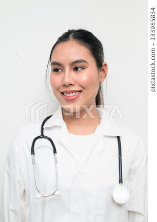 Pensive Happy Woman Doctor with Stethoscope in White Uniform on Plain Background Smiling 133985834