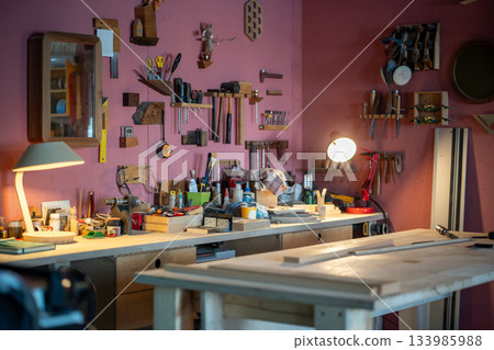 Cozy carpentry workshop interior workplace with tools, equipment and materials on wooden table. Cozy carpentry workshop interior workplace with tools, equipment and materials on wooden table. 133985988