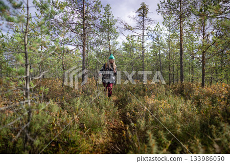 Woman nature explorer on weekend outdoors in autumn forest, healthy walking activity on fresh air. Woman nature explorer on weekend outdoors in autumn forest, healthy walking activity on fresh air. 133986050