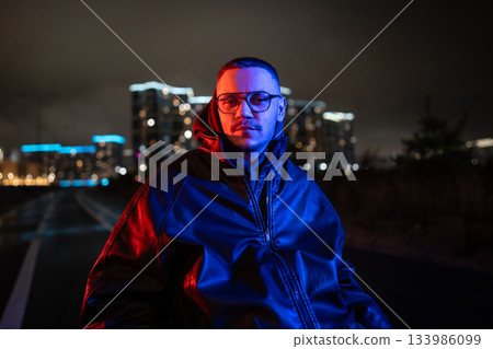 Portrait of thoughtful disabled man in wheelchair in blue red neon rgb light on late night walk. Portrait of thoughtful disabled man in wheelchair in blue red neon rgb light on late night walk. 133986099