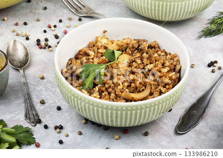 Bowl of buckwheat porridge on table. 133986210