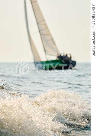 Sailing regatta in the Gulf of Finland at sunny day, sailing yacht competing in a race, splashing water from under the boat, teamwork, board the boat 133986487