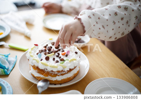 Children decorating cakes / Homemade sweets for the family Children decorating cakes / Homemade sweets for the family 133986808