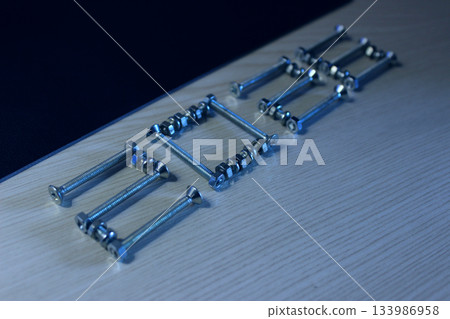 Bolts and nuts laid out on a wooden surface in the shape of the inscription 2026 Bolts and nuts laid out on a wooden surface in the shape of the inscription 2026 133986958