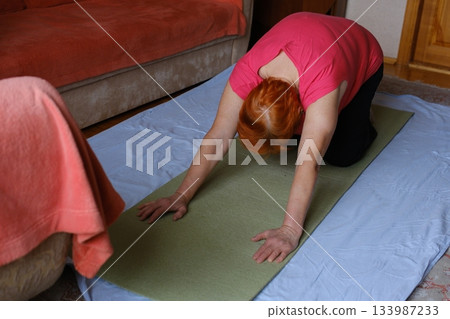 Yoga stretching mat Pleasant 65-Year-Old Woman Does Exercises At Home On A Yoga Mat Yoga stretching mat Pleasant 65-Year-Old Woman Does Exercises At Home On A Yoga Mat 133987233