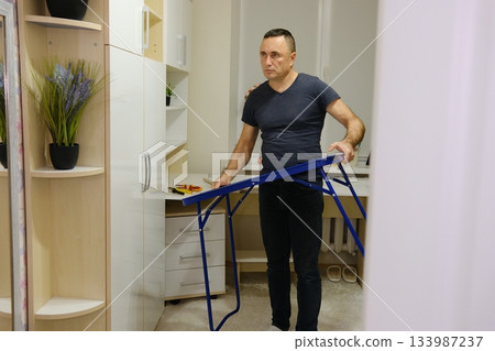 Young man assembling shelf unit in bedroom Young man assembling shelf unit in bedroom 133987237