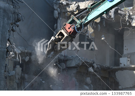 A dilapidated apartment building being demolished. Demolition work using large heavy machinery. A dilapidated apartment building being demolished. Demolition work using large heavy machinery. 133987765