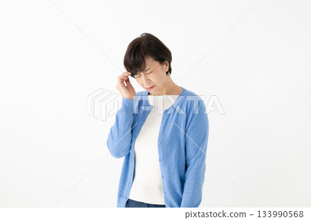 一位女士感到肩膀僵硬和疲勞。 一位女士感到肩膀僵硬和疲勞。 133990568