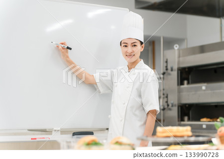 A female instructor who teaches at cooking seminars, vocational schools, and employee training 133990728
