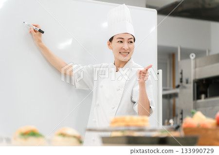 A female instructor who teaches at cooking seminars, vocational schools, and employee training 133990729