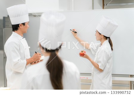 A female instructor who teaches at cooking seminars, vocational schools, and employee training 133990732