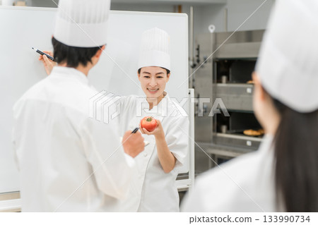 A female instructor who teaches at cooking seminars, vocational schools, and employee training 133990734