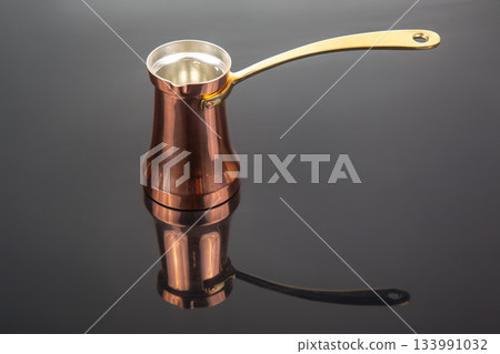 Shiny copper cezve with a golden handle, used for brewing Turkish coffee Shiny copper cezve with a golden handle, used for brewing Turkish coffee 133991032