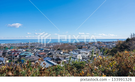 A panoramic view of a residential area from a hilltop with blue skies and the sea A panoramic view of a residential area from a hilltop with blue skies and the sea 133991326
