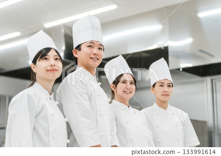 Chefs and cooks in chef coats standing in the kitchen Chefs and cooks in chef coats standing in the kitchen 133991614