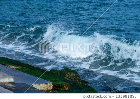 Detail of splashing ocean waves and wet seawall Detail of splashing ocean waves and wet seawall 133991853