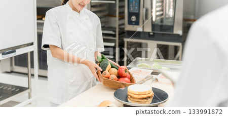在烹飪研討會、職業學校和員工培訓中授課的女性講師 在烹飪研討會、職業學校和員工培訓中授課的女性講師 133991872
