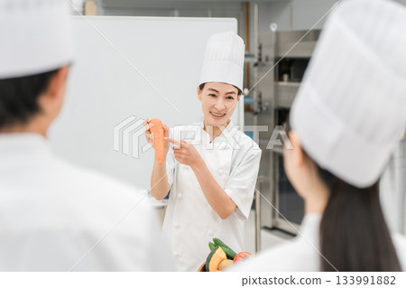 A female instructor who teaches at cooking seminars, vocational schools, and employee training 133991882
