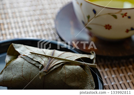 Japanese sweets wrapped in persimmon leaves and green tea Japanese sweets wrapped in persimmon leaves and green tea 133992811
