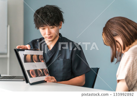 一名男醫生在醫院檢查期間一邊展示內視鏡影像一邊進行講解。 一名男醫生在醫院檢查期間一邊展示內視鏡影像一邊進行講解。 133992892