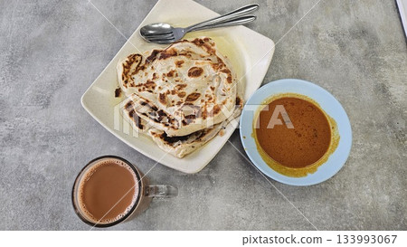 This is a group of food with Roti Canai, Teh Tarik and Curry This is a group of food with Roti Canai, Teh Tarik and Curry 133993067