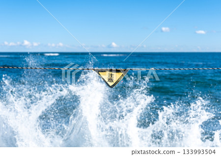 海岸繩索上的警示標誌和洶湧的波浪 133993504