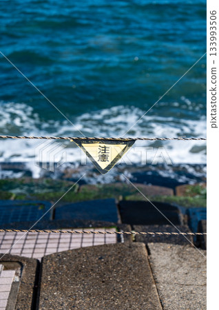 海灘上巨浪滔天,警示牌提醒人們注意海上事故風險。 海灘上巨浪滔天,警示牌提醒人們注意海上事故風險。 133993506