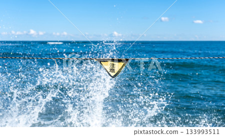 巨浪拍打著海洋，警示標誌提醒人們注意海上事故。 133993511