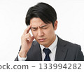 一名男子頭痛欲裂，雙手摀著太陽穴。 133994282