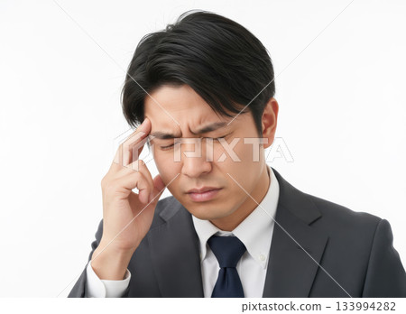 一名男子頭痛欲裂，雙手摀著太陽穴。 133994282