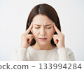 女人頭痛欲裂，雙手摀住太陽穴 133994284