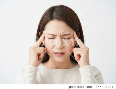 女人頭痛欲裂，雙手摀住太陽穴 133994284