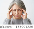 女人頭痛欲裂，雙手摀住太陽穴 133994286