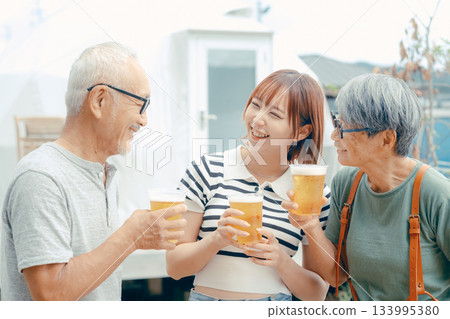 A scene of three people standing at the beach and toasting A scene of three people standing at the beach and toasting 133995380