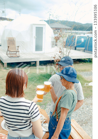 A scene of three people standing at the beach and toasting 133995386