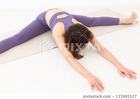Middle-aged woman in yoga wear doing exercises Middle-aged woman in yoga wear doing exercises 133995527