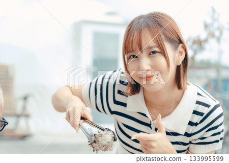 A woman in her 20s grilling seafood on the beach 133995599